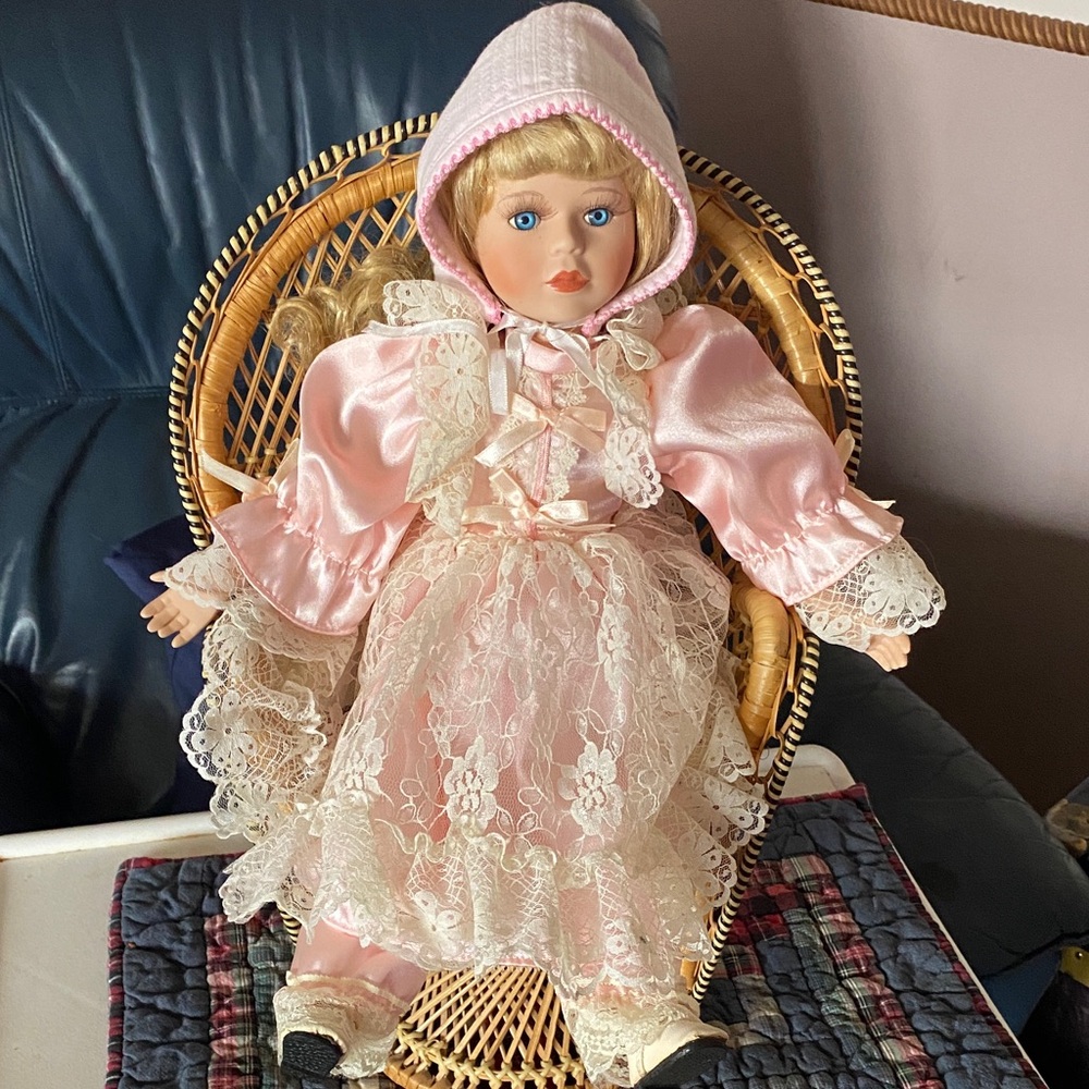 Angelina Pink Lace Doll on a wicker chair